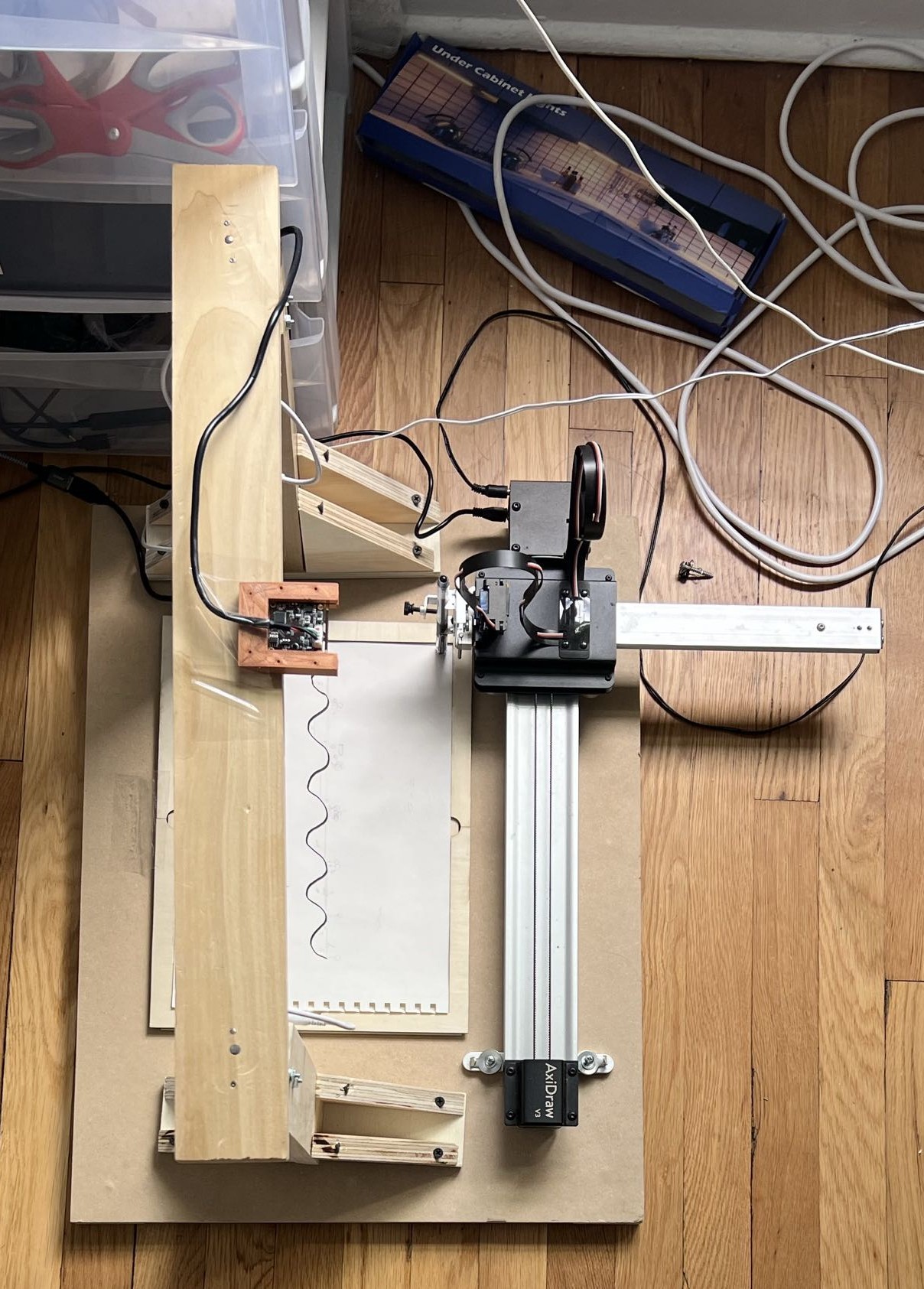 The wooden camera bridge under construction, spanning the Axidraw and bolted to its base plate