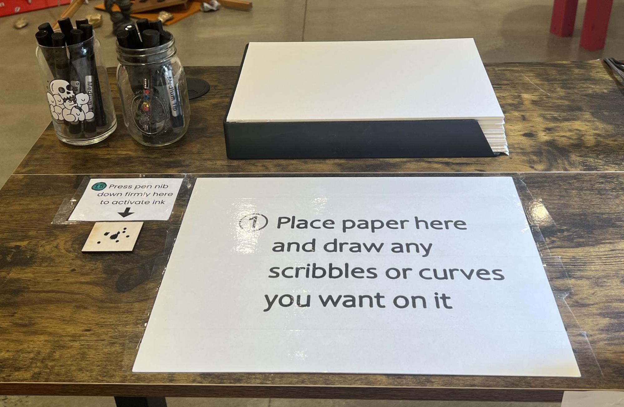 The first station: pens, a stack of paper and the plaque instructing visitors to draw