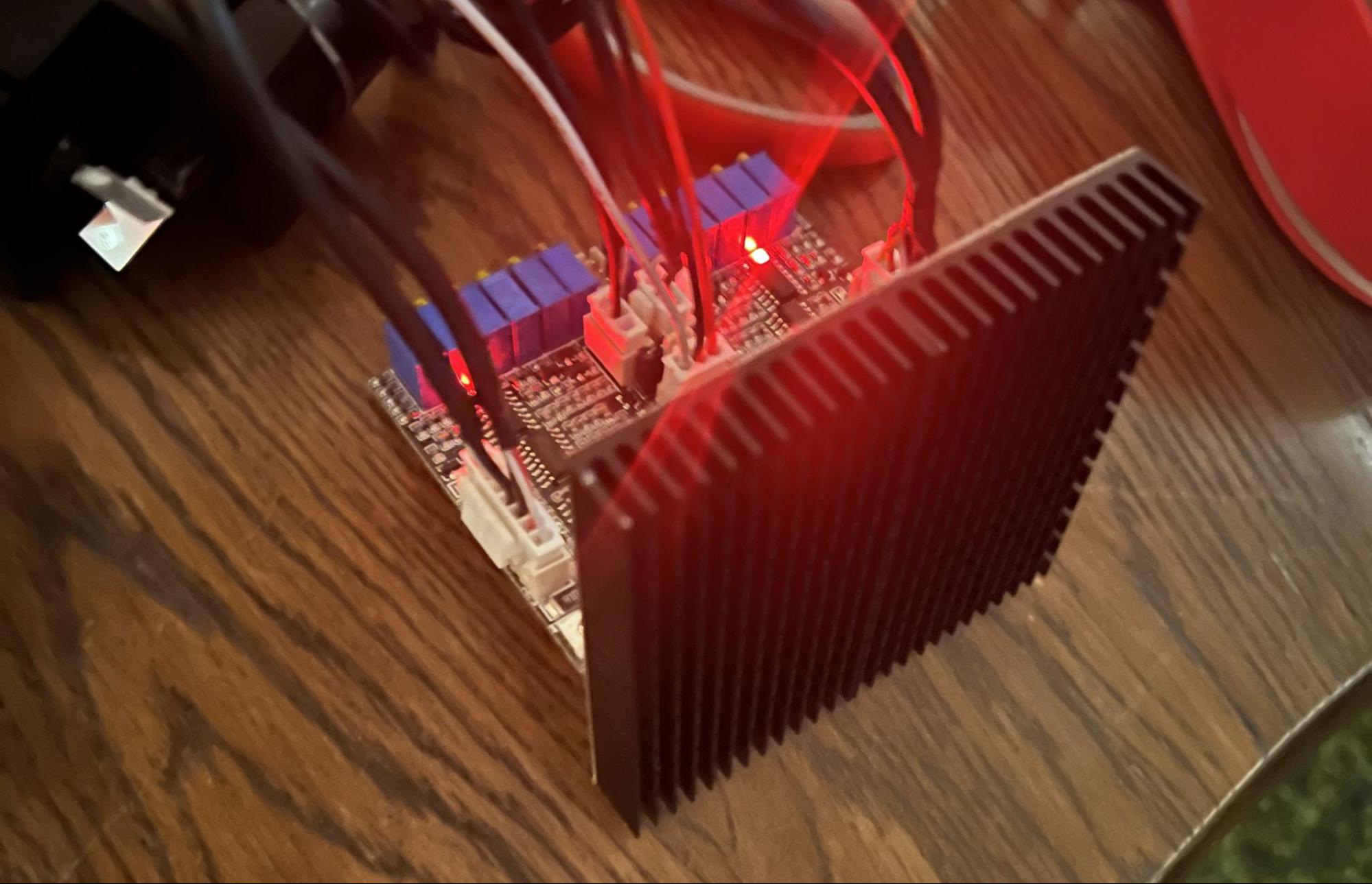 A large waffle heatsink attached to the galvo driver board, lit red