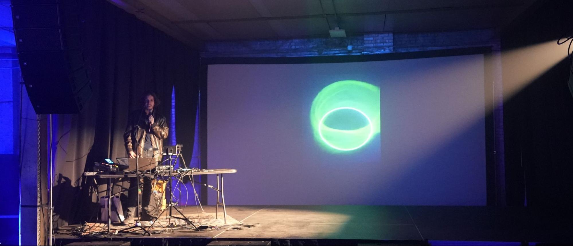 Giving the Lightsail talk on stage at Tech25, with a synced circle pattern projected on the screen behind